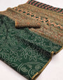 Enticing Dark Green Printed Cotton Silk Saree With Twirling Blouse Piece